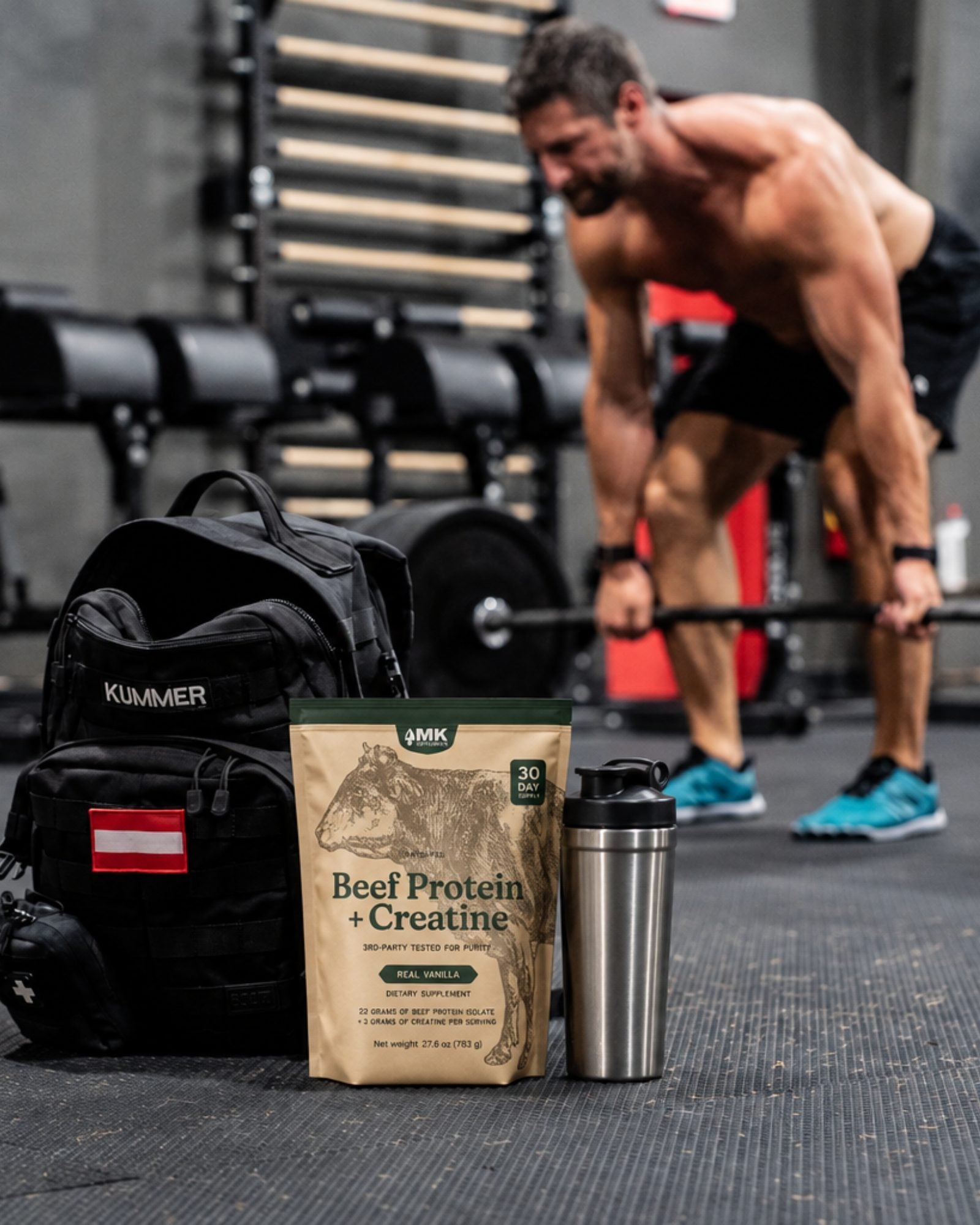 Michael Kummer deadlifting in the gym with a pouch of Beef Protein + Creatine in the foreground
